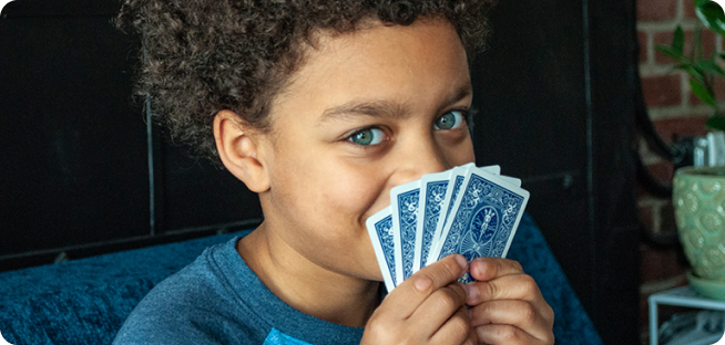 A kid holding cards up to his face